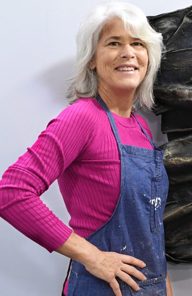 Artist Gina Vernon poses in an apron